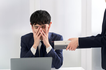 仕事量に塞ぎ込むビジネスマン