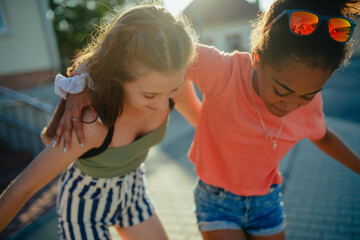 Teenager girl best friends greeting each other, hugging. Girls spending time outdoors in city...