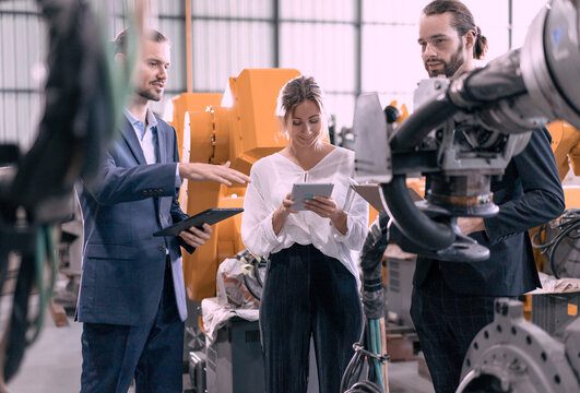 Businesswoman visit robotics engineering industry talking with engineer manager planning modern automated development technology. Group of people meeting for innovation solution efficiency in factory