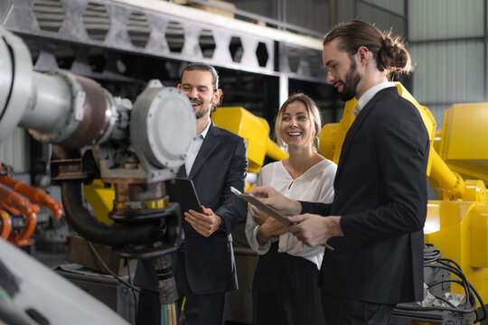 Businesswoman visit robotics engineering industry talking with engineer manager planning modern automated development technology. Group of people meeting for innovation solution efficiency in factory