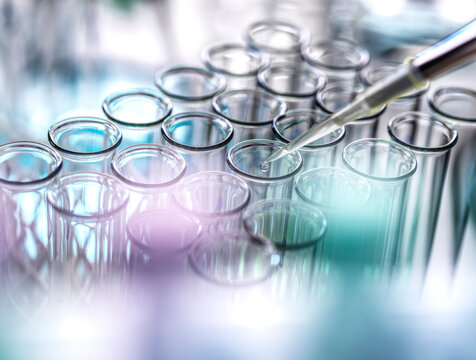 Scientist pipetting drop of sample in test tubes at lab - Powered by Adobe