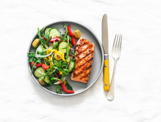 Delicious diet lunch, dinner - grilled salmon and fresh vegetable salad on a light background, top view - 785060654