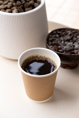 Take away cup of hot black coffee on table