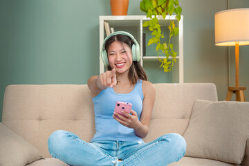 Smiling chinese young woman sitting looking at social media with a smartphone