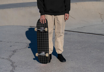 Mockup of skater holding customized skateboard - obrazy, fototapety, plakaty