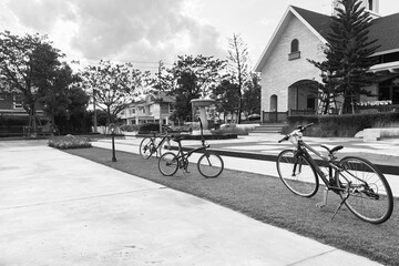 Black and white image of outdoor open space suburb small town with bicycles, classic buildings, fountain and park show peaceful and loneliness atmosphere. - 785079469