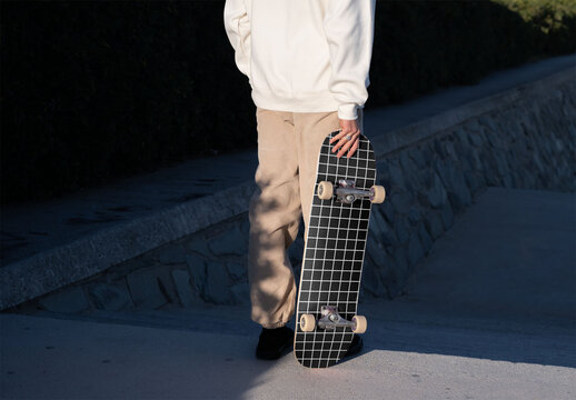 Mockup of skater holding customizable skateboard, low section