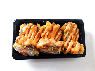 Photo of sushi with sauce on top. This food is a typical Japanese food. Sushi is made from rice with the addition of seafood, eggs and fresh vegetables