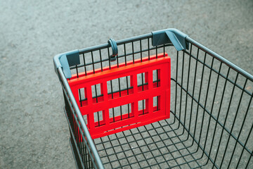 Empty shopping cart trolley in supermarket. Consumerism, shopping spree and seasonal discount concept.