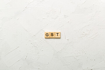 GST word written on wood block. GST text on cement table for your desing, concept