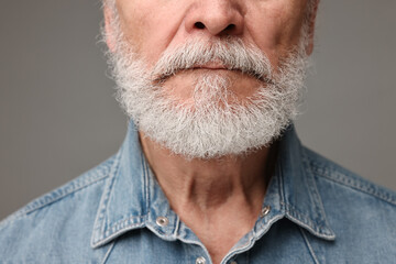 Man with mustache on grey background, closeup