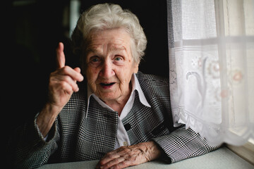 Photograph of a mature lady with a significantly raised index finger. - 785096086