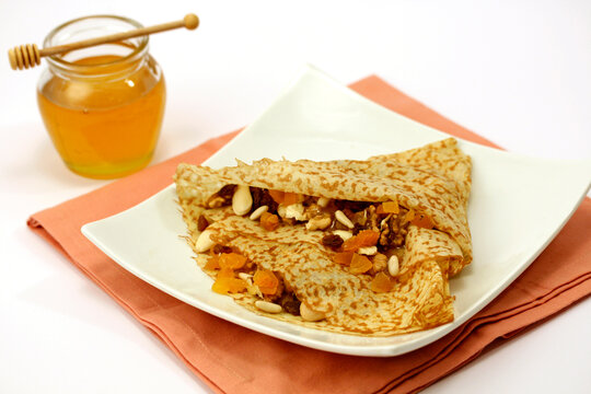 Crepes with honey and dried fruit.