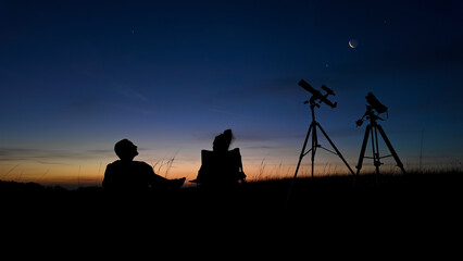 People enjoying watching and stargazing with astronomy telescopes outdoors in nature, observing...