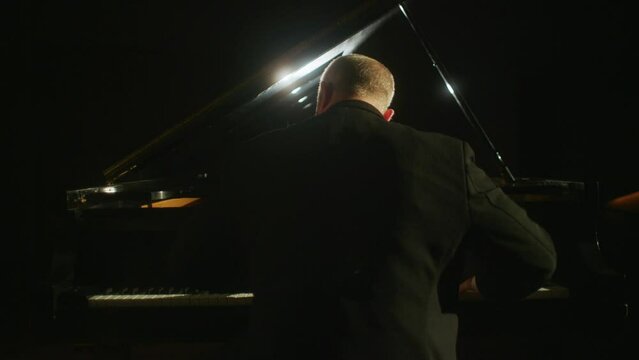 Man  plays piano from behind