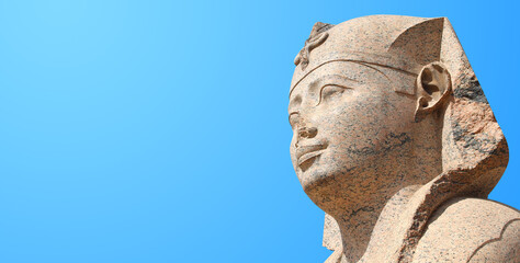 Horizontal banner with face of Sphinx in Famous landmark Serapeum of Alexandria, Alexandria, Egypt, North Africa. Sphinx in Roman temple Serapeum. On blue sky background