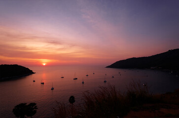 Beautiful sunset on Phuket bay with yachts in the lagoon.