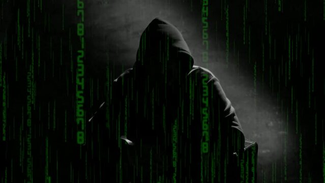 Anonymous man in a hood interview video footage. Mysterious man sitting on a chair and talking. Anonymous hacker interview with no visible face, computer hacker conceptual background