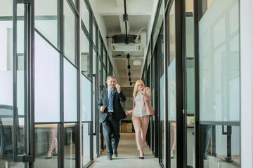 Caucasian happy business people dancing together in an office corridor
