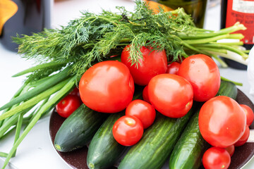 Plate of natural foods with cherry tomatoes, cucumbers, and green onions