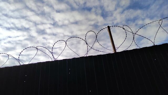Prison fence with metal barbed wire 4K video footage background