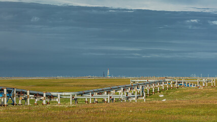 Infrastructure for oil and gas production and transportation. Northern field. Arctic nature. Pipelines. Drilling rig on the horizon