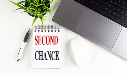 SECOND CHANCE text on notebook with laptop, mouse and pen