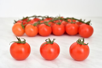 Cherry tomatoes on the light gray marble table texture. Close-up. Selective focus.