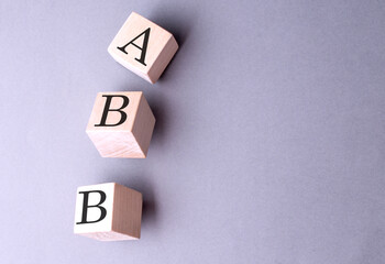ABB word on wooden block on gray background - obrazy, fototapety, plakaty