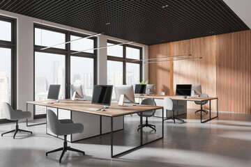 Modern coworking interior with table and pc desktop, panoramic window
