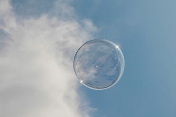 Closeup shot of a soap bubble in the clear blue sky