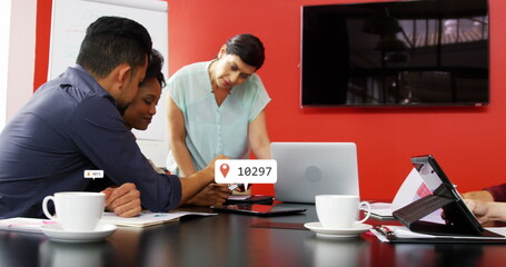 Image of multiple notification bars over diverse coworkers discussing reports in office