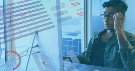 Image of financial data processing over biracial businessman in office