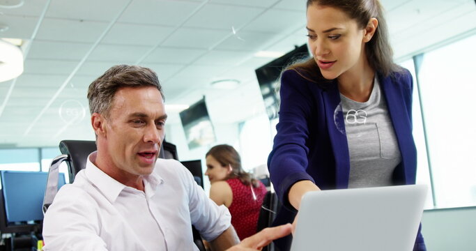 Image of 6g texts in bubbles over diverse coworkers discussing reports on laptop in office - Powered by Adobe