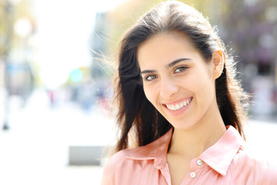 Portrait of a happy woman with white smile in the street