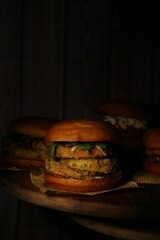 Classical burgers on wooden table with dark background