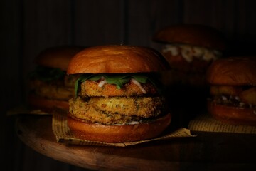 Classical burgers on wooden table with dark background