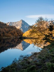 Naklejka premium Vertical shot of lake Landschitzsee reflecting trees and mountains in Salzburg, Austria