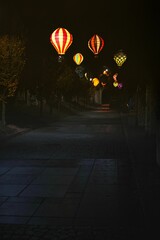 Vertical shot of an alley decorated with lit paper Chinese lanterns at night