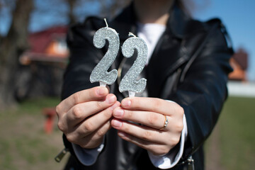 A woman holding birthday numeral candle	