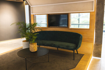 No people present, just stylish room with a green sofa and a round coffee table