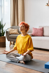beautiful extravagant queer person with red hair in vibrant yellow t shirt meditating at home