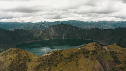 Aerial shot of Quilotoa Volcano and the blue Lake Crater under the fluffy clouds