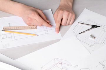 Man creating packaging design at light wooden table, closeup