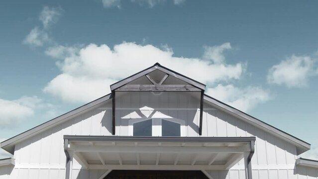 Timelapse of a bright sky with clouds moving over a wooden wedding hall on a sunny day