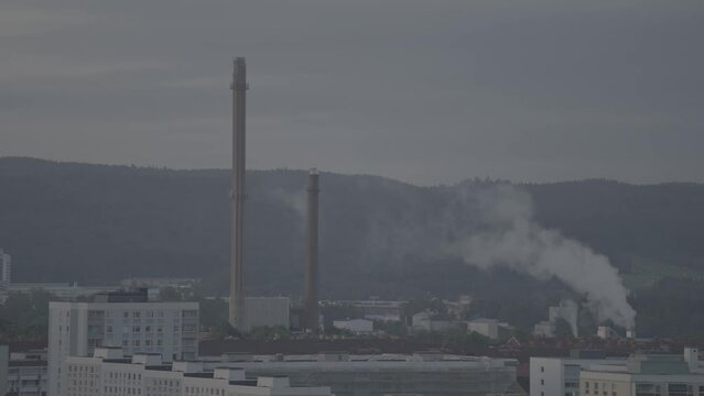 Drone shot of chimneys and smoke coming out from industrial district
