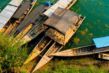 Fototapeta na wymiar Aerial shot of wooden boats parked in the shore of a lake during daytime