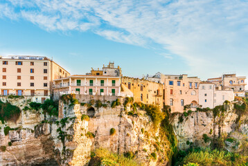 Obraz premium scenic travel landscape of beautiful historic town Tropea in Italy with old antique buildings, vintage houses on a high rock cliff above sea and amazing blue sky on background