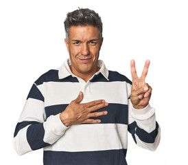 Middle-aged Latino man taking an oath, putting hand on chest.