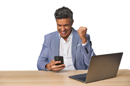 Celebratory middle-aged Hispanic man with laptop on phone call